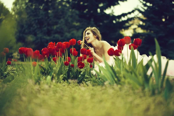 Leende flicka med Röda tulpaner — Stockfoto