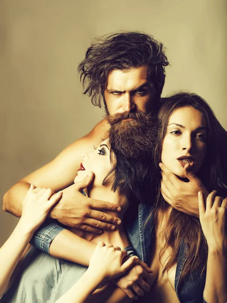 Uomo barbuto con due giovani ragazze attraenti — Foto Stock