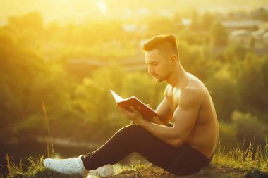 Kitap açık olan dalgın kaslı adam