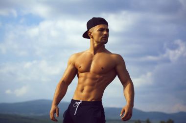 Gökyüzü arka plan üzerinde seksi kaslı adam