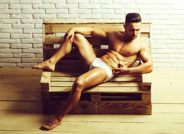 Bel homme musclé sur banc en bois — Photo