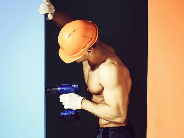 잘생긴 사나이 젊은이 손으로 몸통과 오렌지 헬멧에 Abs 화려한 배경에 — 스톡 사진