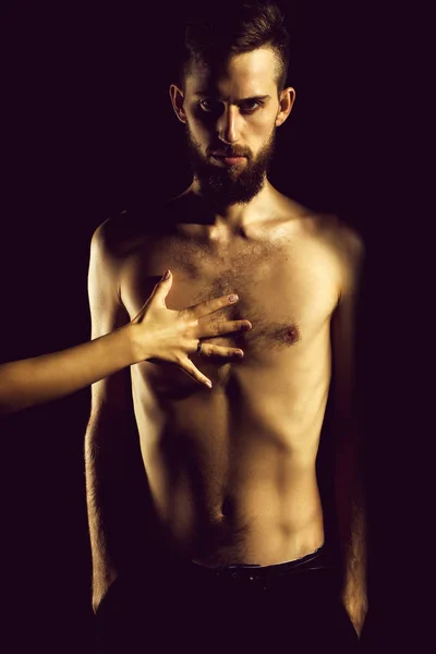 slim bearded man with thin bare torso isolated on black