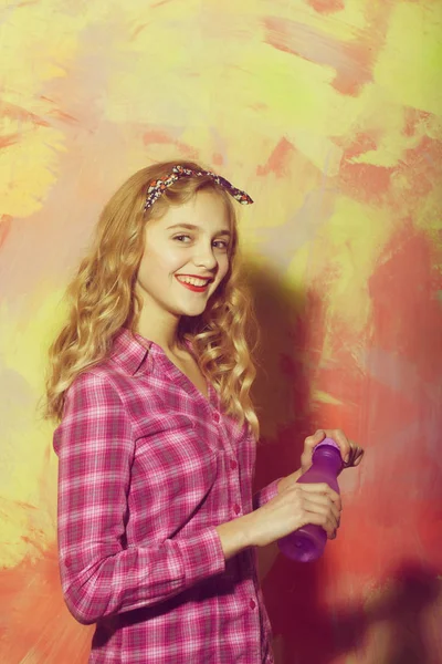 Весела красива дівчина посміхається фіолетовою пляшкою води — стокове фото