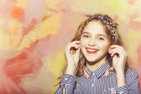 Menina bonita alegre ouve música com fones de ouvido — Fotografia de Stock