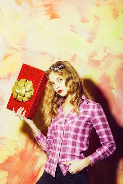 Söt flicka med röd presentbox med gyllene båge — Stockfoto