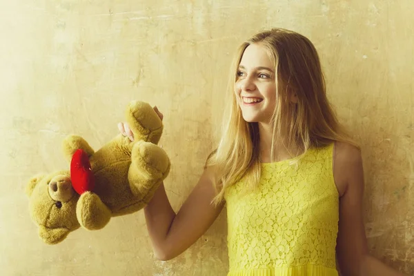 Όμορφος ευτυχισμένος κορίτσι με αρκουδάκι παιχνίδι στο κίτρινο φόρεμα — Φωτογραφία Αρχείου