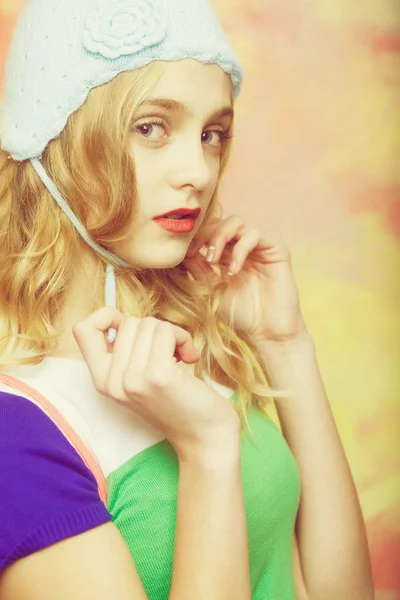 Hezká dívka vazby roztomilé pletené modré čepice — Stock fotografie