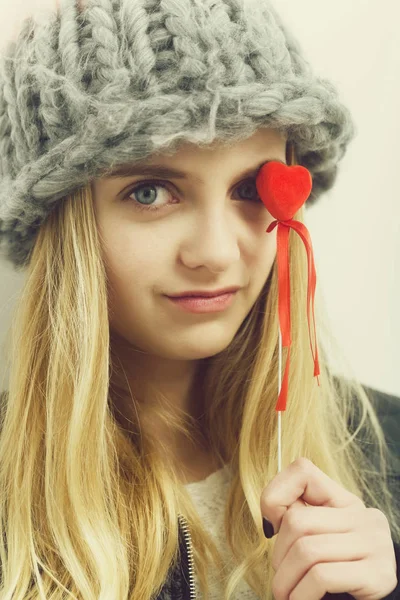 Милая молодая девушка в модной шляпе с красным сердцем — стоковое фото