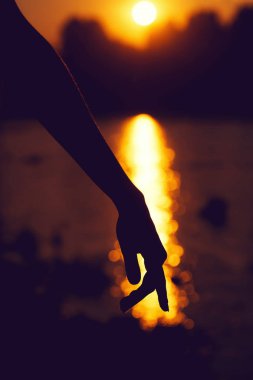 Güzel gün batımı üzerinde el