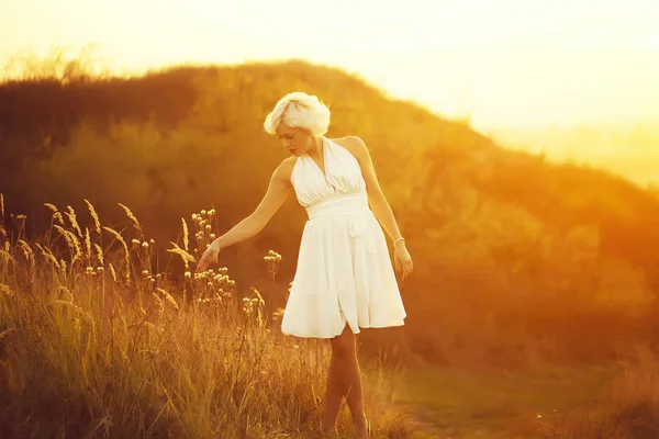 Жінка ходить на заході сонця — стокове фото