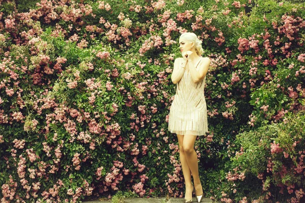 漂亮的女人在玫瑰花丛附近 — 图库照片
