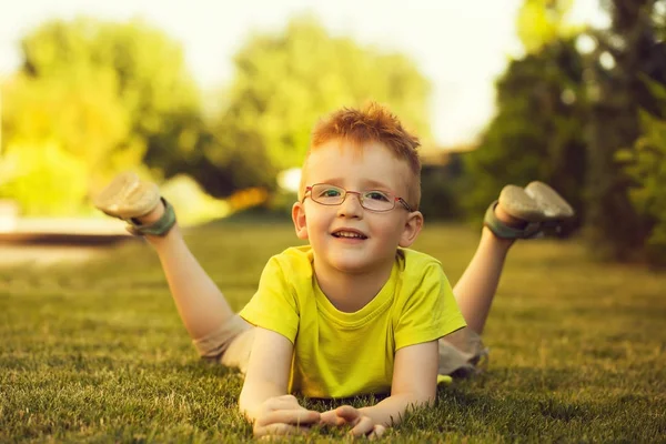 快乐宝贝男孩在草地上眼镜的红头发 — 图库照片