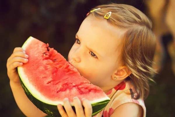 Flicka äter röd vattenmelon utomhus — Stockfoto