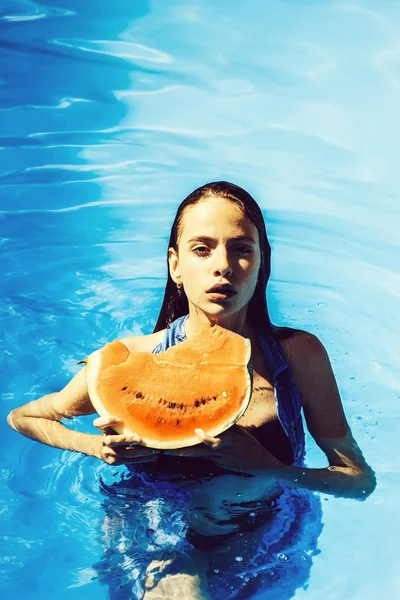 Mujer con sandía en piscina —  Fotos de Stock