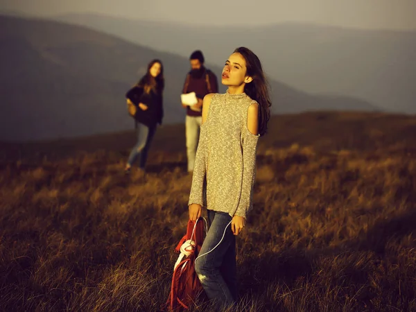 かなりセクシーなかわいい若い女の子または緩いセーターと晴れた日の山の上に背中に赤いバックパックの女性 — ストック写真