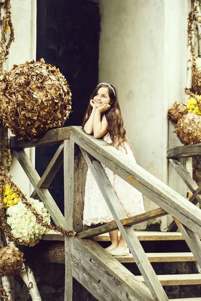 Chica sonriente en las escaleras con decoración floral —  Fotos de Stock