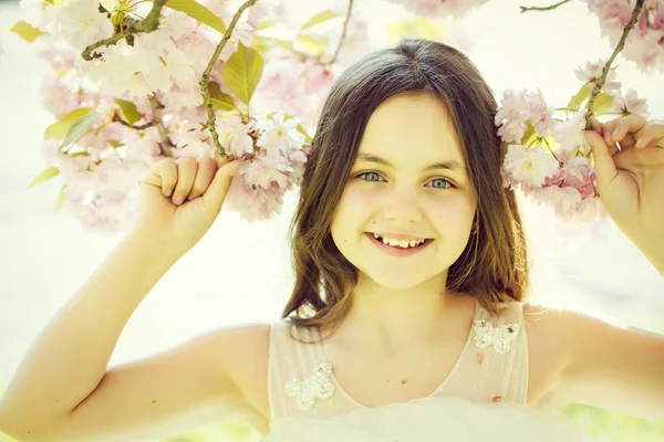 Kleines lächelndes Mädchen in Blüte — Stockfoto