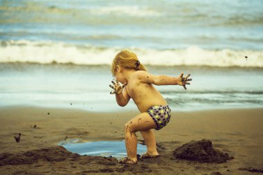 Şirin çamurlu bebek çocuk ıslak kum ile çalış