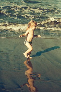 Islak kum deniz boyunca şirin neşeli bebek çocuk ishal