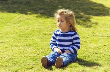 Şirin bebek çocuk parkı yeşil çimenlerin üzerinde oturan