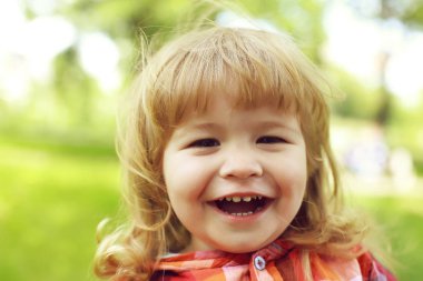 Yeşil doğal zemin üzerine mutlu küçük çocuk