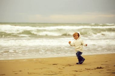 Neşeli çocuk kumsalda çalıştıran 