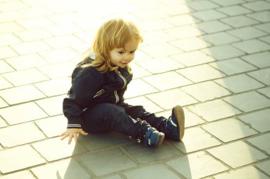 Kaldırımda küçük çocuk oturur