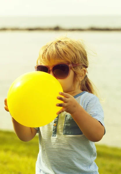 黄色の風船で遊ぶかわいい赤ちゃんの少年 — ストック写真