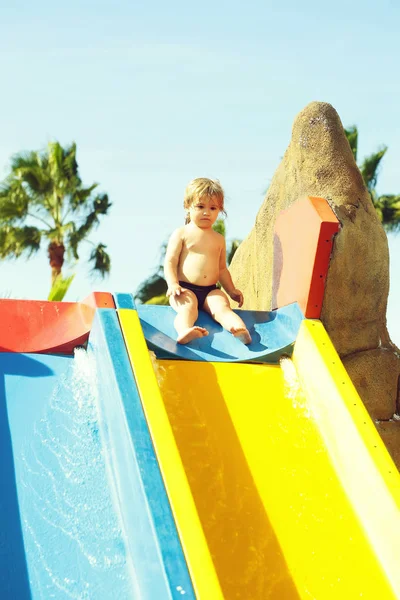 Aranyos baba fiú ül a tetején vízi csúszda — Stock Fotó