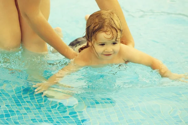 Schattige babyjongen leert om te zwemmen met moeders hulp — Stockfoto