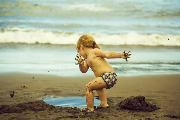 Mignon boueux bébé garçon joue avec humide sable — Photo