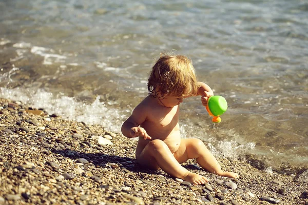 Niño sentado en el agua de mar — Foto de Stock