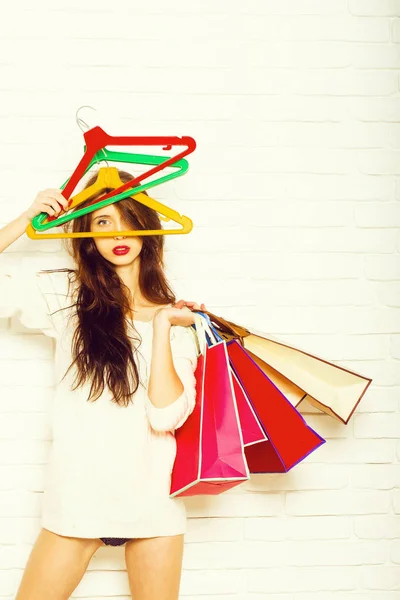 Mulher com sacos de compras e cabides — Fotografia de Stock