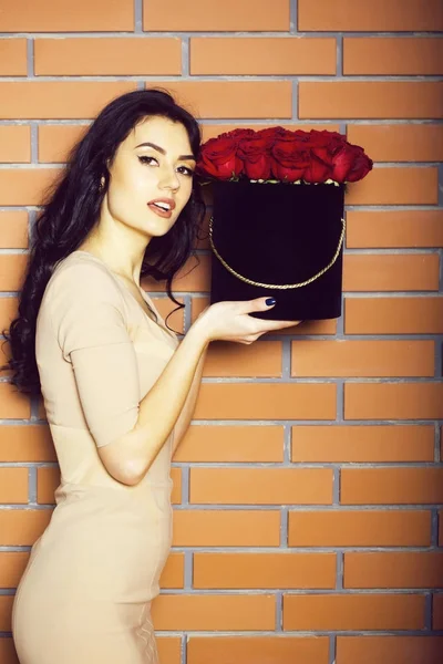 Bella ragazza posa con rose rosse in scatola — Foto Stock