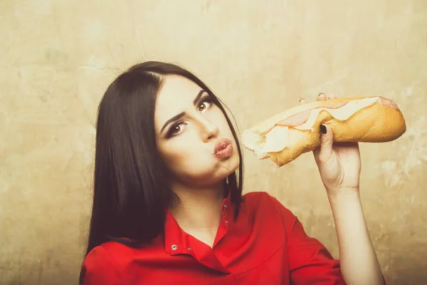 Seksi güzel esmer kadın büyük sandviç ya da hamburger yiyor — Stok fotoğraf