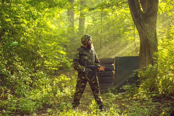 Soldier with rifle in forest — Stock Photo, Image