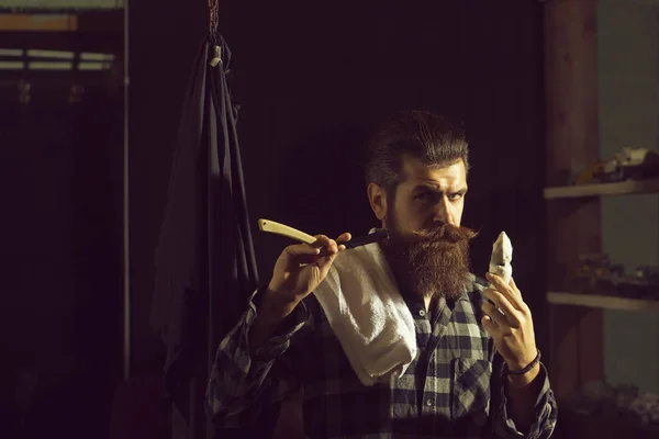 大胡子的男人用剃须刀刮胡子 — 图库照片