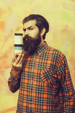 Ciddi adam tutarak iki kozmetik kavanoz sakallı