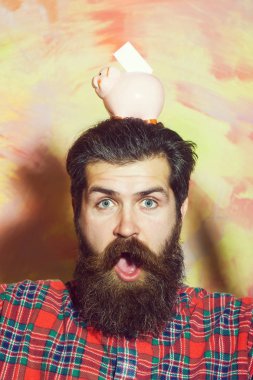 Şaşırmış sakallı adam ile kafasına pembe seramik kumbara