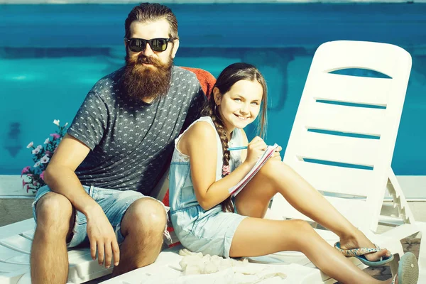 happy small girl and man at swimming pool