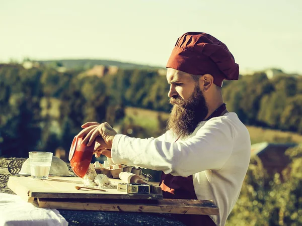 Man chef laying out dough