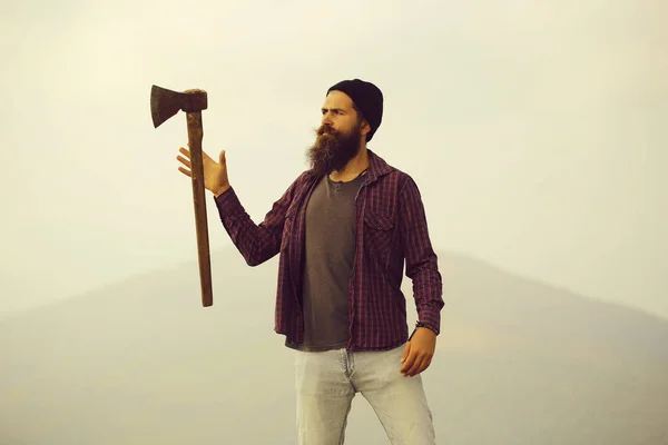 Bearded man with ax on mountain — Stock Photo, Image