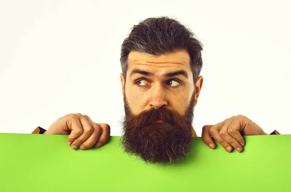 Удивленный бородатый человек хипстер с зеленой бумагой изолированы на белом — стоковое фото