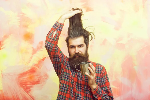 Бородатый мужчина со стильными бахромой волос и металлической кружкой — стоковое фото