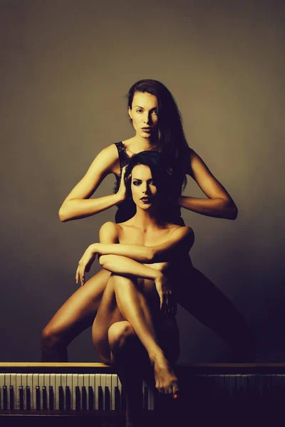 Duas mulheres bonitas com corpo nu no piano — Fotografia de Stock