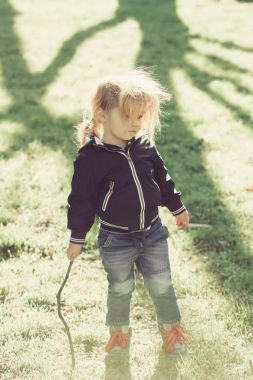 Çocuk çocuk mavi ceket ve kot oyun sopa ile