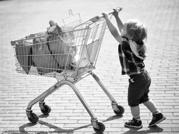 買い物用手押し車を押してかわいい男の子 — ストック写真