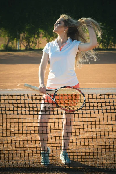 Sportlerin in sexy Uniform hält Tennisschläger am Netz — Stockfoto
