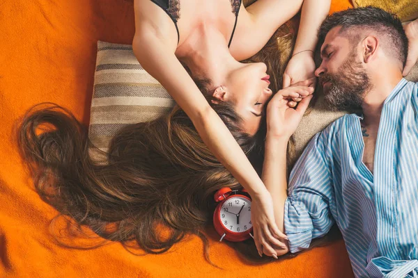 Пара закоханих спить на підлозі з будильником . — стокове фото